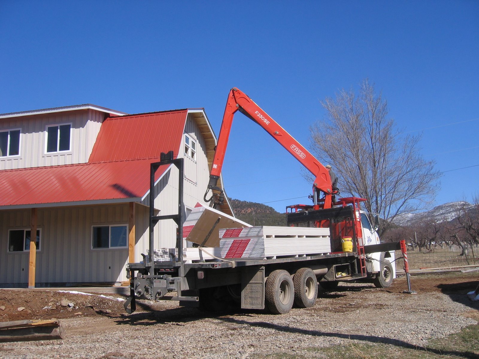 This boom trick is delivering drywall sheets for the new shop.