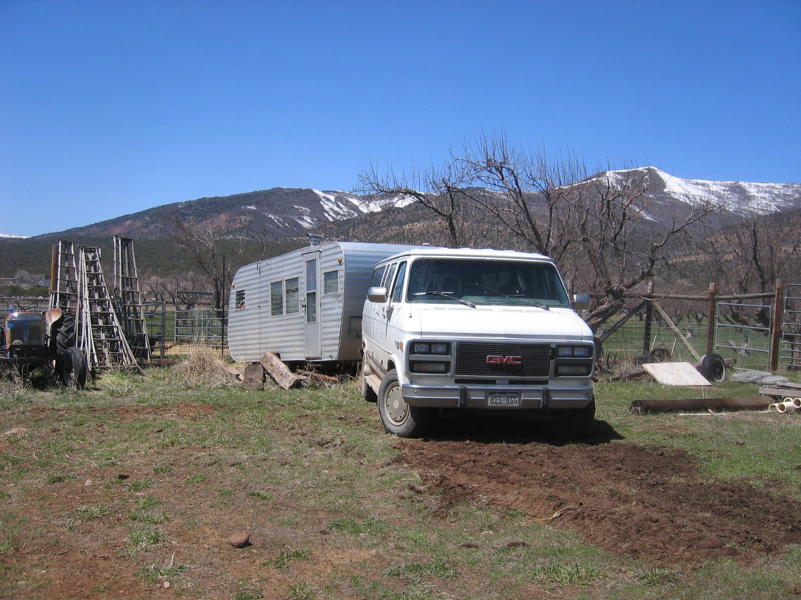The trailer is hooked up to a GMC van, ready to be towed away. 
