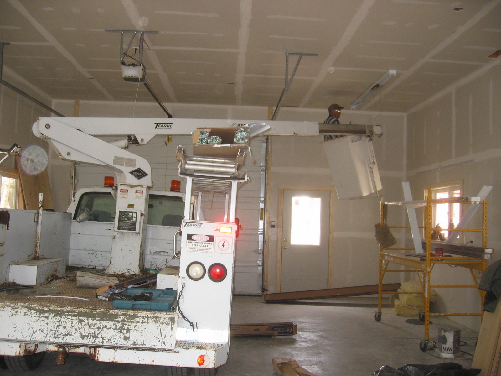 Jake uses a cherry picker to finish the electrical inside the new shop. 