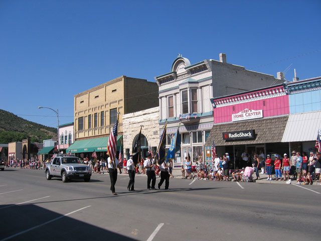 A police cruiser flanks several flag bearers walking through the parade.