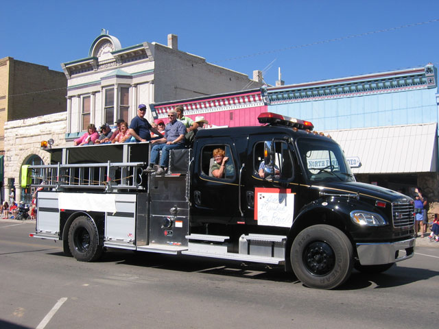 The fire department has loaded up a truck with people to drive through the parade.