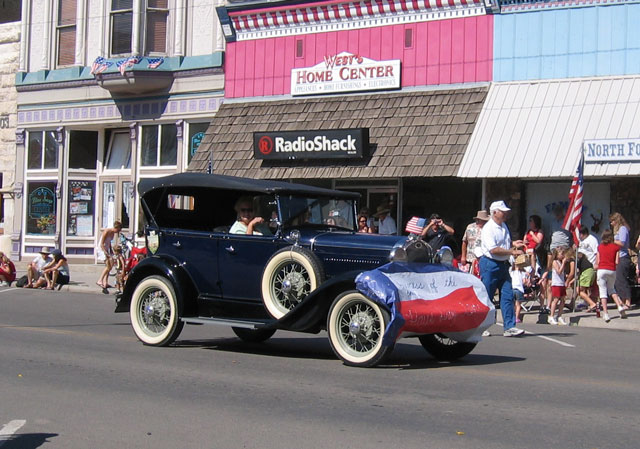 A resident with a classic car drives through.
