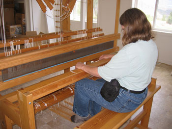 Oogie tests the treadles on the new loom.