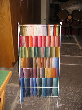 A display of different colored wool threads illustrates the myriad shades used in the tapestry.