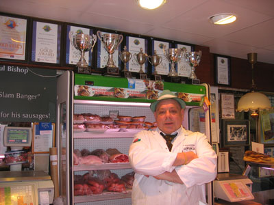 Mr. Paul Bishop poses in from of his trophies and a case of meat.