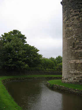 A picture showcasing the remains of Nunney Castle and its moat. 
