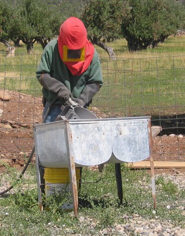 Ken is suited up and sandblasting an apple press. 