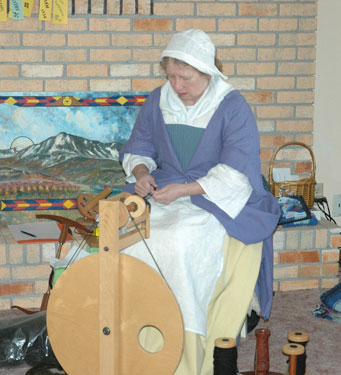 Oogie wears a period-appropriate outfit for the Golden Age of Piracy while hand-spinning some wool.