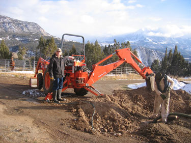 Ken and Flat Stanley operate the tractor to expose the septic tank.