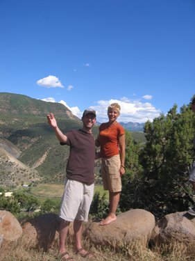 The visitors pose for a photo with the mountains in view behind. 
