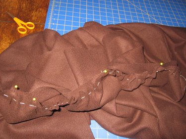 This picture showcases the pleats and stitches in the cloak fabric. 