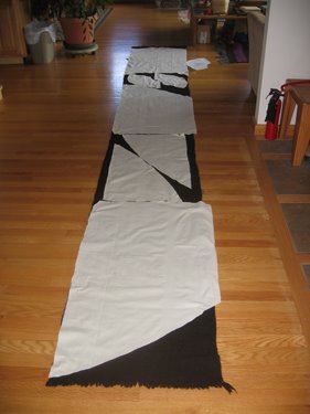 Oogie's cloak pattern is laid out over a long piece of woven wool fabric.