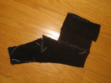 A few small pieces of woven wool fabric are sewn together in various ways.