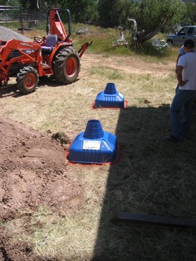 Two blue plastic molds denote the placement of footers for the new porch.