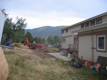 Bill uses the tractor to fill holes in advance of the concrete truck. 