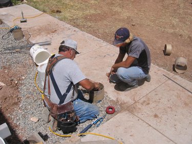 The construction crew prepares and pours footers for the new porch. 