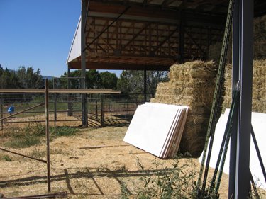 Several primed plywood panels are set aside, ready for use. 