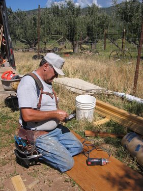 This worker is getting ready to prime and paint some lumber. 