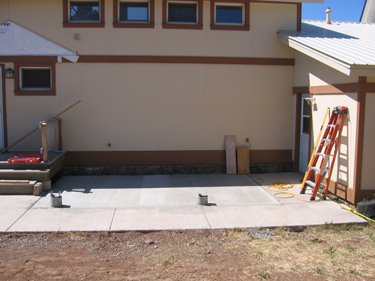Various construction materials are scattered neatly around the new porch. 