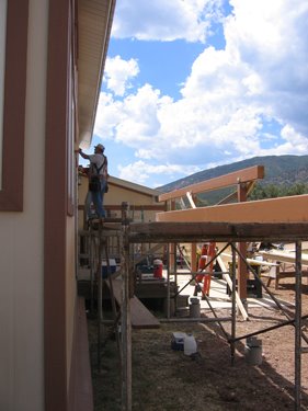 The construction crew is in the process of putting the rafters over the new porch. 