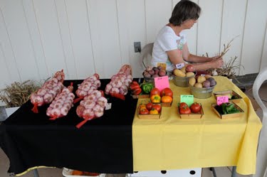 Monica is cleaning and braiding garlic for sale. 
