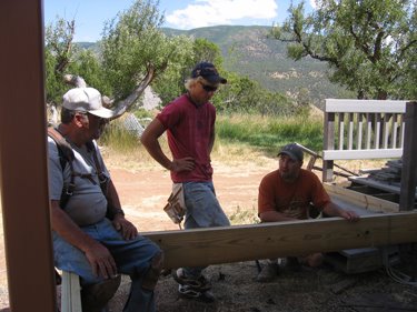 The construction crew is contemplating their next step in the porch construction process. 