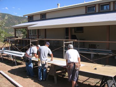 The crew bends and crimps the metal roof panels to fit together. 