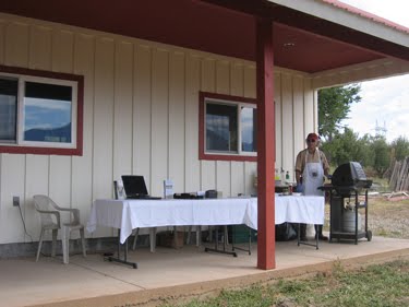 Ken mans the grill, preparing smoked kolbassi sausages for samples. 