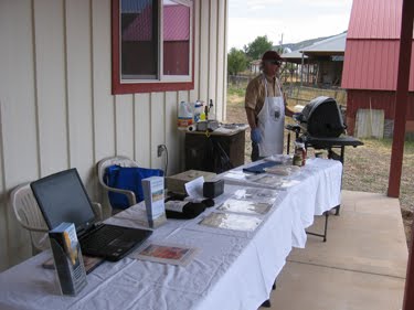 Ken mans the grill, preparing smoked kolbassi sausages for samples. 