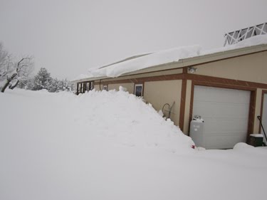 The garage is nearly up to its eaves in snow.