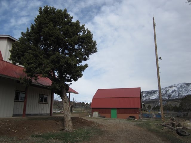 A view of a partly cloudy spring sky over the red barn. 