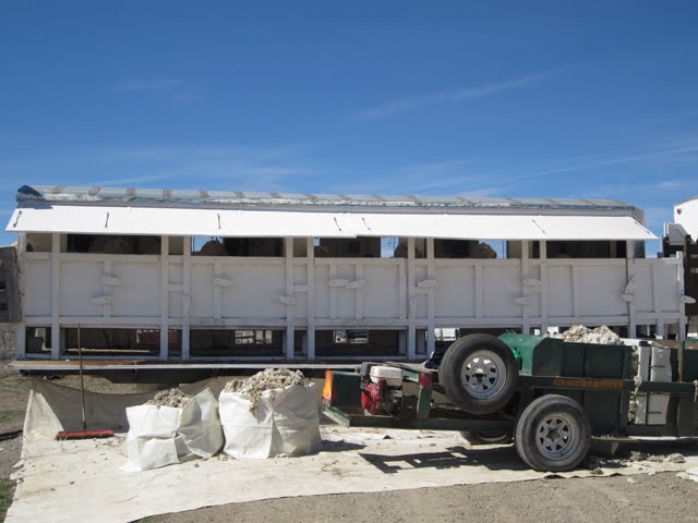A mobile sheep shearing station can be seen in action, with the sheared rovings collected from the back.