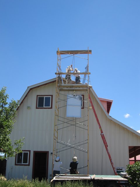 In the process of hoisting a third solar panel. 