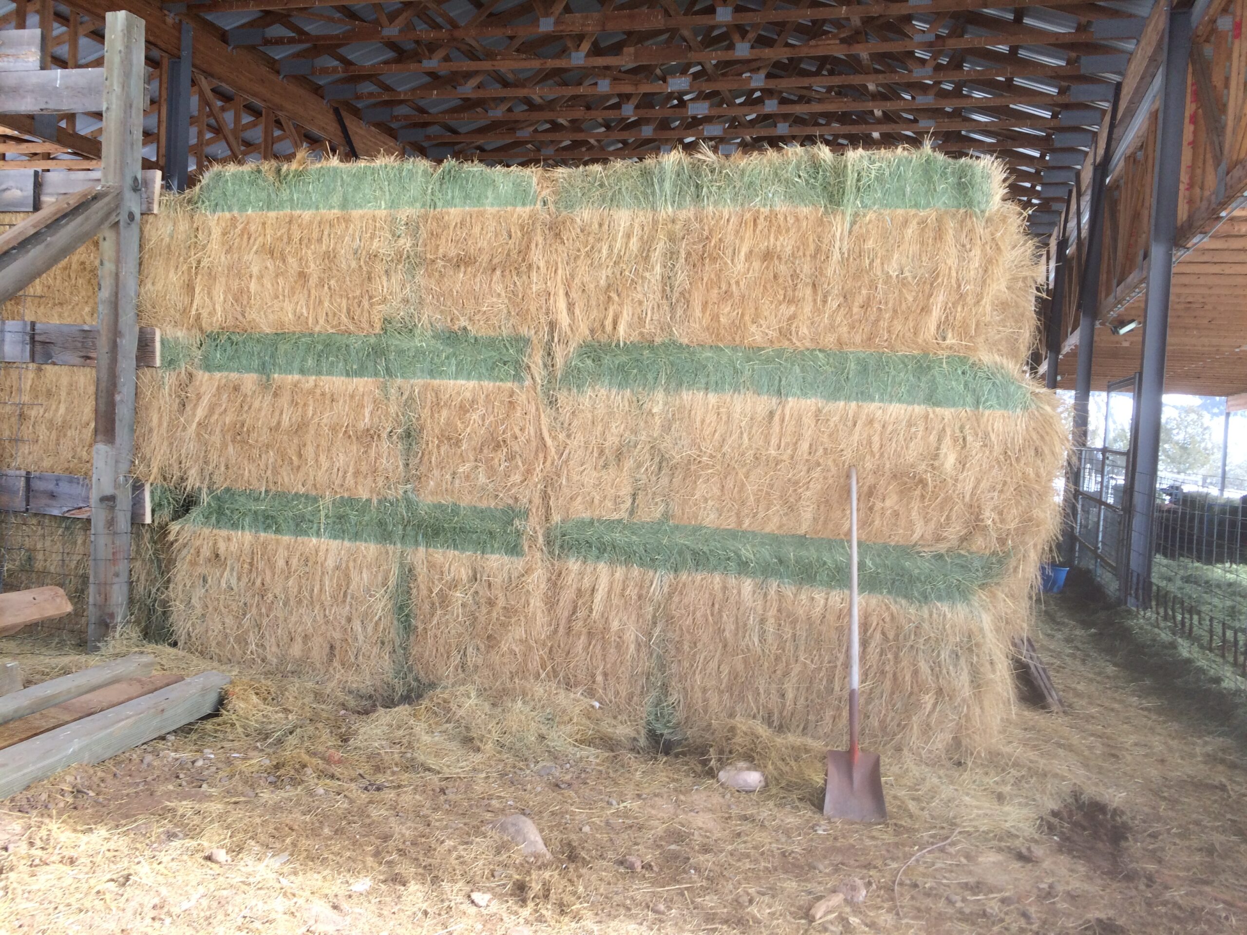 Wood timbers have been removed, exposing stacks of hay bales.