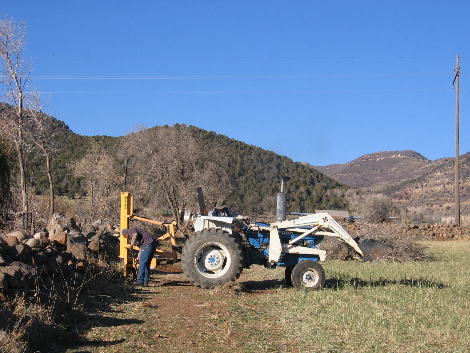 Larry is using his post hole digger to place new fence posts.