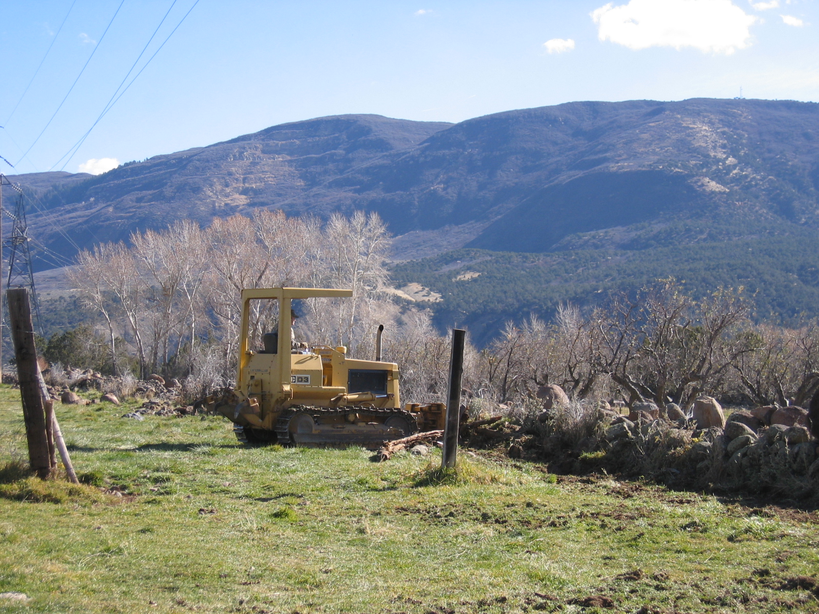Enos is using his bulldozer to clear the north fence line of rocks. 