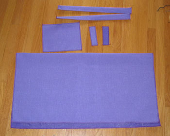 Pieces of fabric required for making a sheep coat are laid out on the floor. 