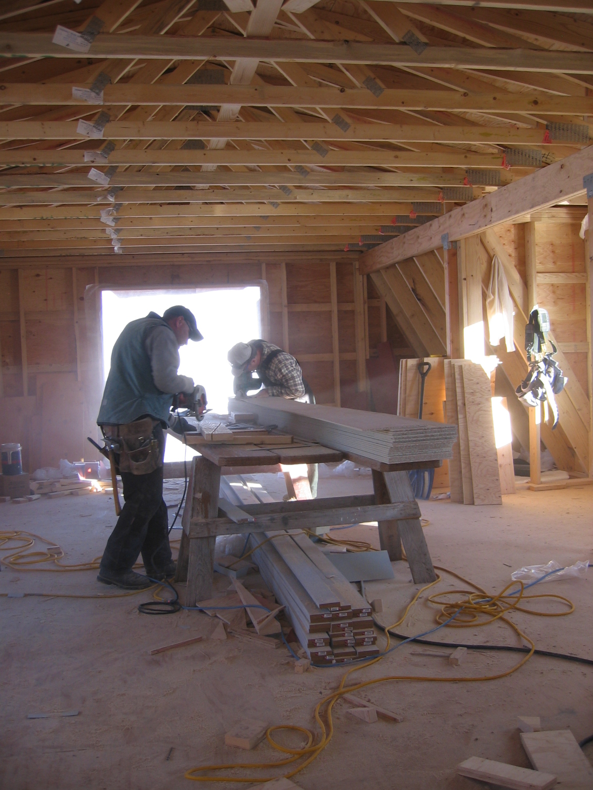 Construction workers are in the upper level of the shop.