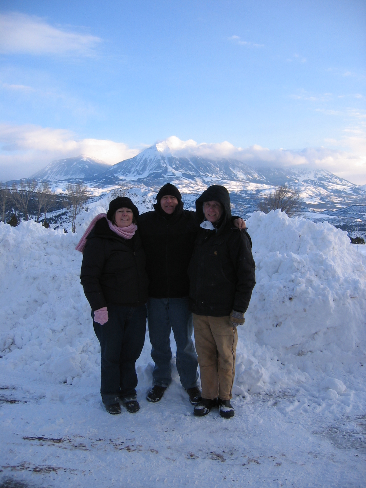 The guests pose for a photo against a backdrop of snow and mountains.