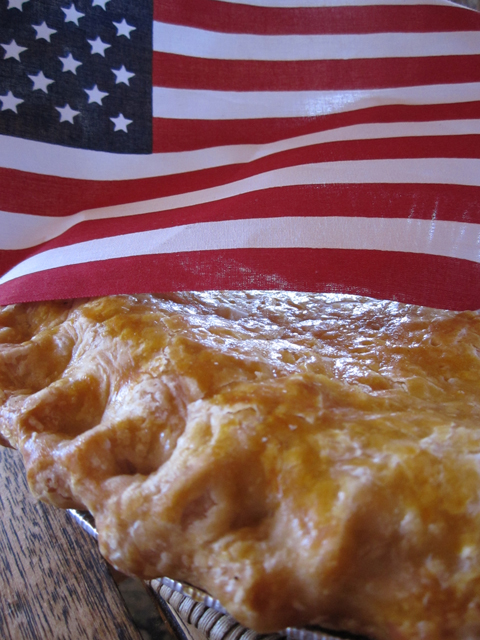 An American flag and a rhubarb pie make up this picture.