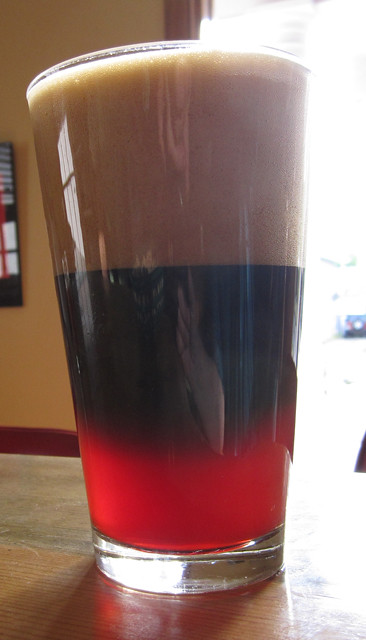 A tall glass of cherry soda mixed with stout. 