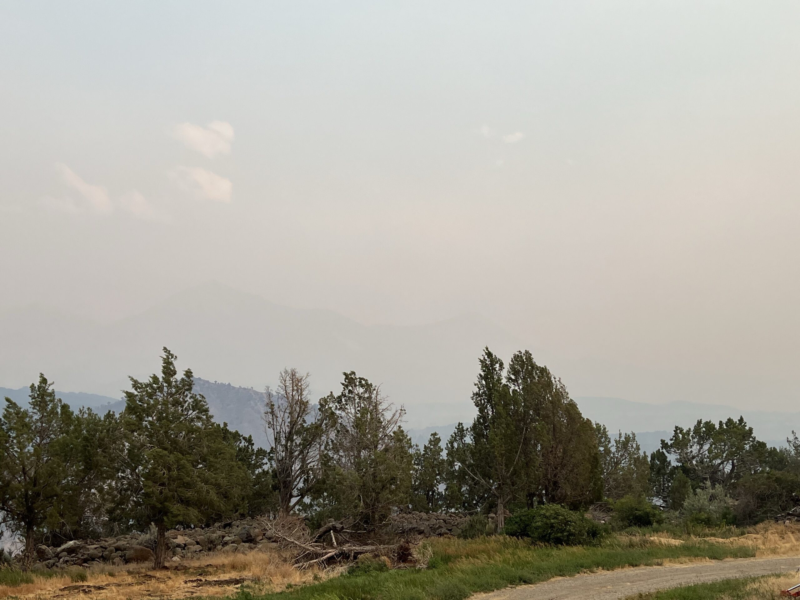 Smoke obscures the view of the mountains in the distance. 